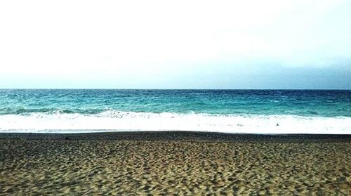 Scenic view of beach against cloudy sky