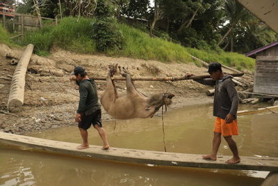 Full length of men standing on riverbank