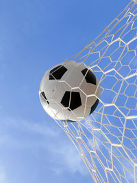 Soccer ball hitting in goal post against blue sky