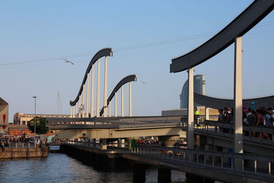 Bridge over river in city against clear sky