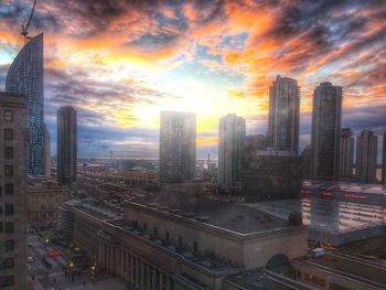 Skyscrapers in city at sunset