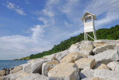 Scenic view of rocks by sea against sky