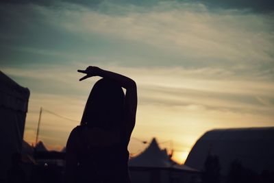 Silhouette of man standing on mountain at sunset