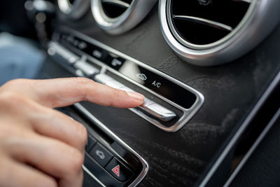 Cropped hand of man using mobile phone in car