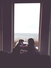 Rear view of couple sitting on beach