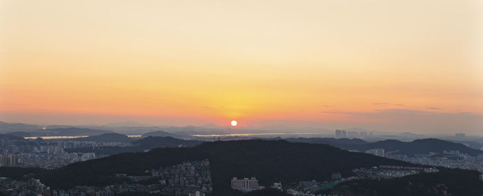 High angle view of townscape against orange sky