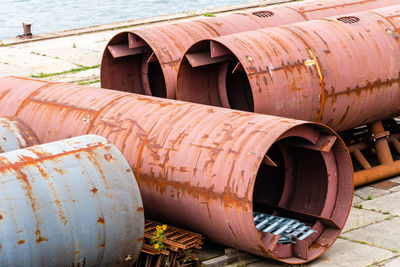 Large steel ducts and pipes rusty and abandoned in the dock of a harbour