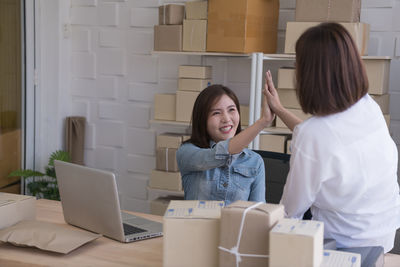 Young woman using phone while sitting in office