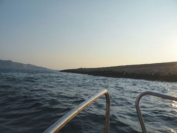 Boat sailing in sea against clear sky