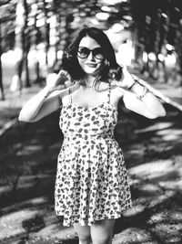 Portrait of young woman wearing sunglasses standing outdoors