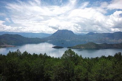 Scenic view of mountains and lake against cloudy sky