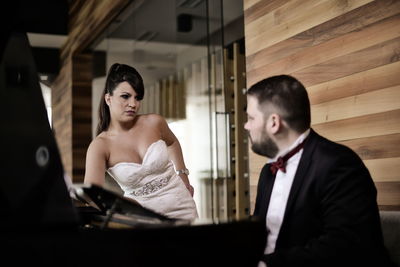 Well dressed bride and groom looking at each other in home