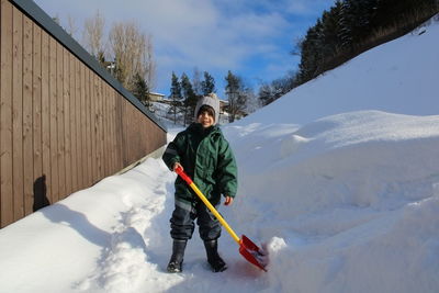 Boy skiing on snow covered field