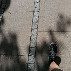 Low section of person standing on footpath