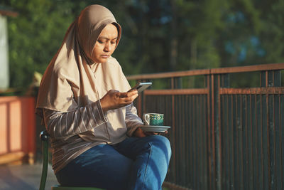 Muslim woman sitting enjoying tea in the sun