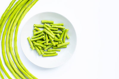 High angle view of vegetables in bowl against white background