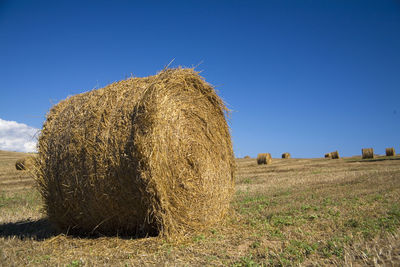 Hay bales on field against sky