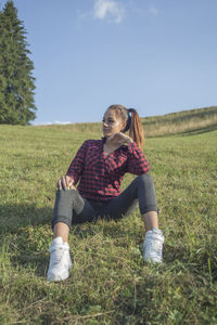 Full length of woman sitting on field