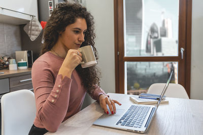 Young woman is working from home on the computer during restrictions due to the covid-19 pandemic