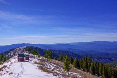 Scenic view of snowcapped mountains against blue sky