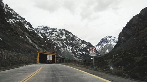 Road amidst snowcapped mountains against sky