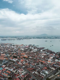 High angle view of townscape by sea against sky