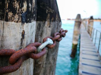 Close-up of rusty chain on sea shore