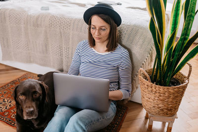 Portrait of young woman using mobile phone at home