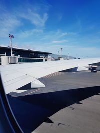 Airplane on airport runway against sky