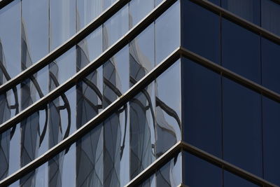 Low angle view of glass building against sky