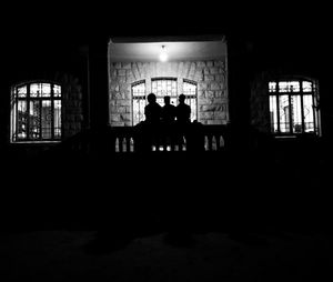 Silhouette people in illuminated building