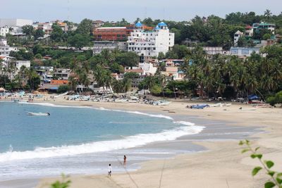 Scenic view of beach by buildings in city