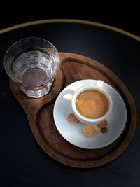 High angle view of coffee and water in wooden tray on table