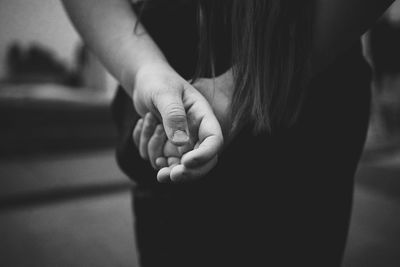 Close-up of woman holding hands at home