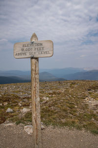 Information sign on landscape against sky