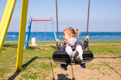 Girl sitting on swing at playground