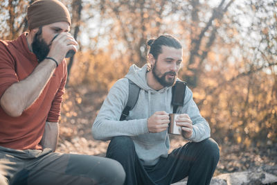 Young man using mobile phone in forest