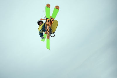 Low angle view of person paragliding against sky