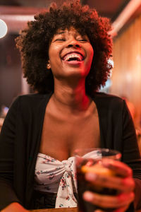 Happy afro woman at bar