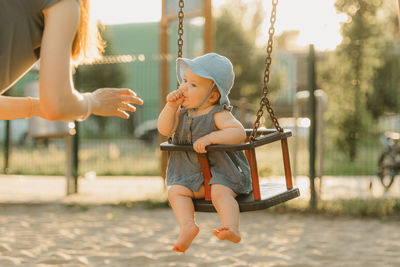 Portrait of young woman sitting on swing