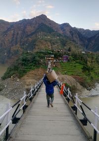 Full length of man walking on footbridge