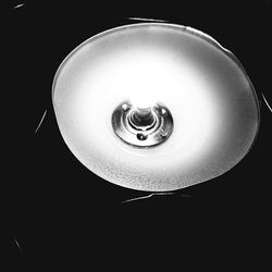 Close-up of light bulb over black background