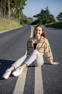 Low section of woman sitting on road