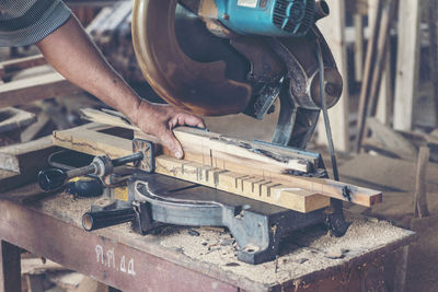 Cropped hands of carpenter working at carpentry workshop