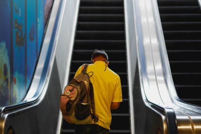 Rear view of man on escalator