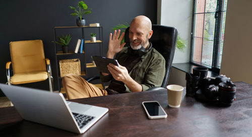 Woman using mobile phone while sitting on table