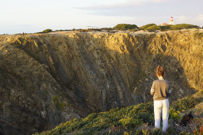 Rear view of woman standing on mountain