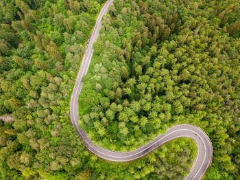 Winding road from high mountain pass, in summer time. aerial view by drone . romania