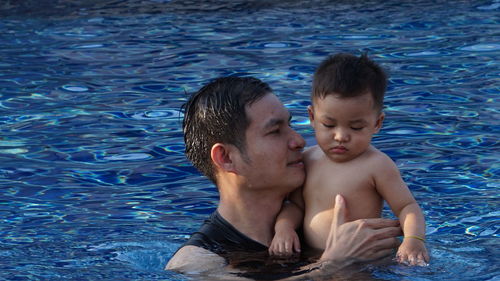 Mother and daughter swimming in pool