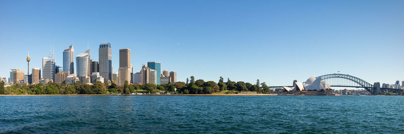 City at waterfront against blue sky